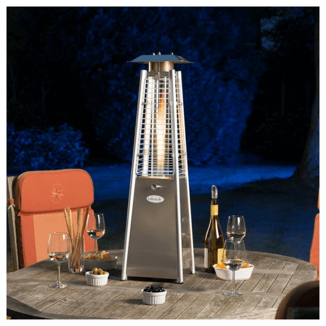 Table-top patio heater on a garden table with a dark garden background.