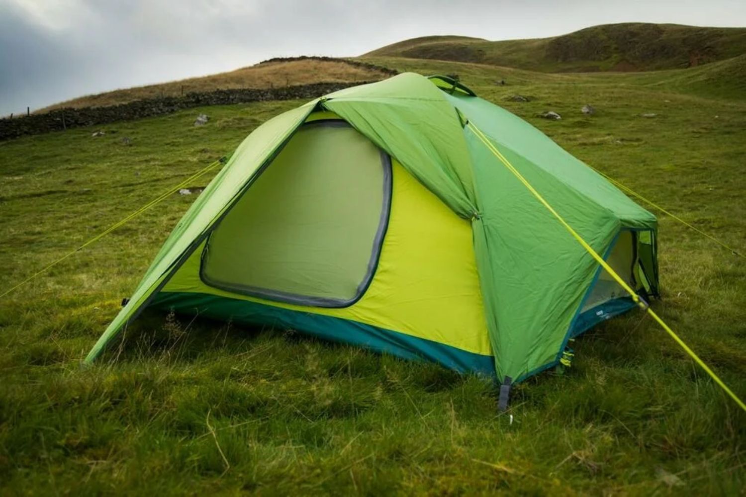 Green tent in empty grass field